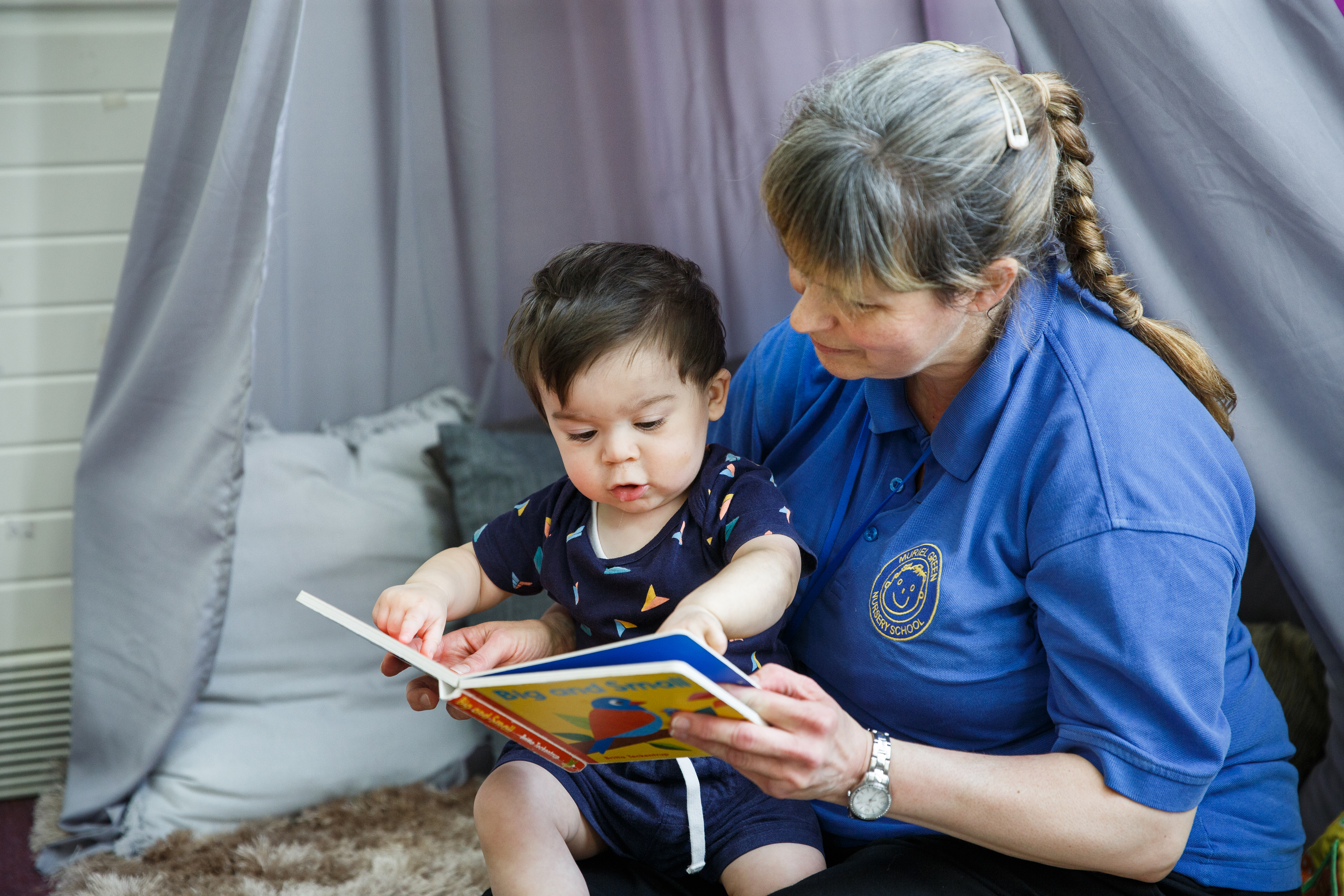 Early Years child with adult, reading a book