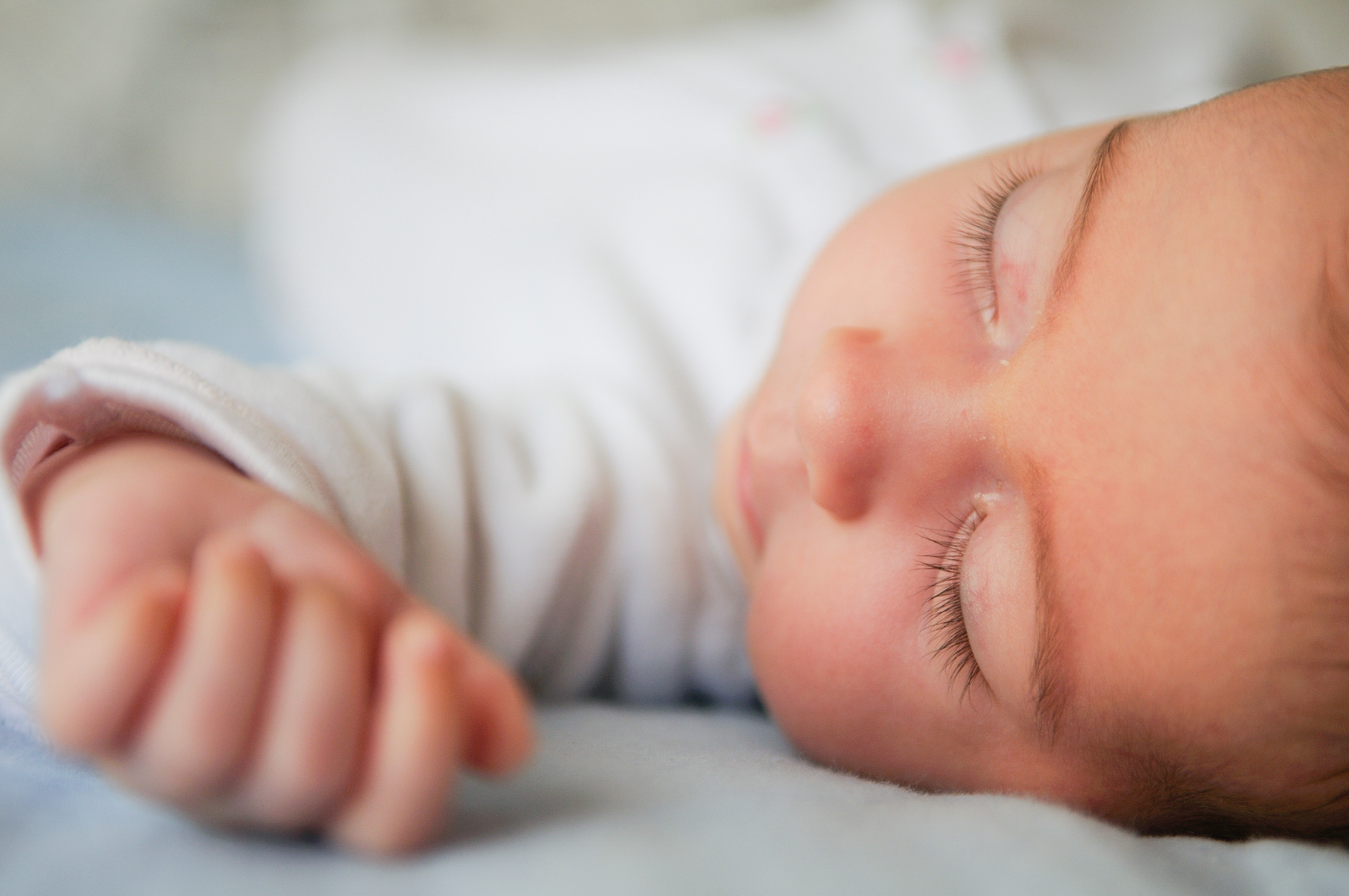 Newborn child sleeping on blue sheets