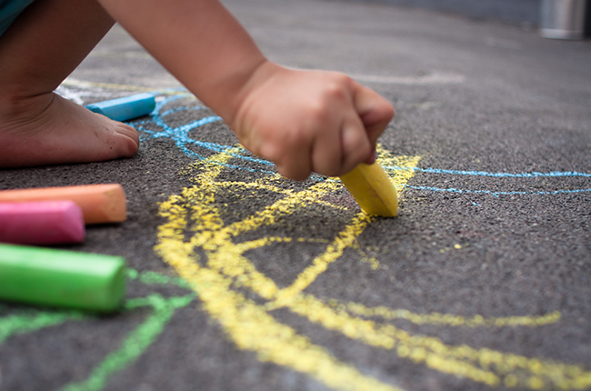 Child drawing on the floor with chalk