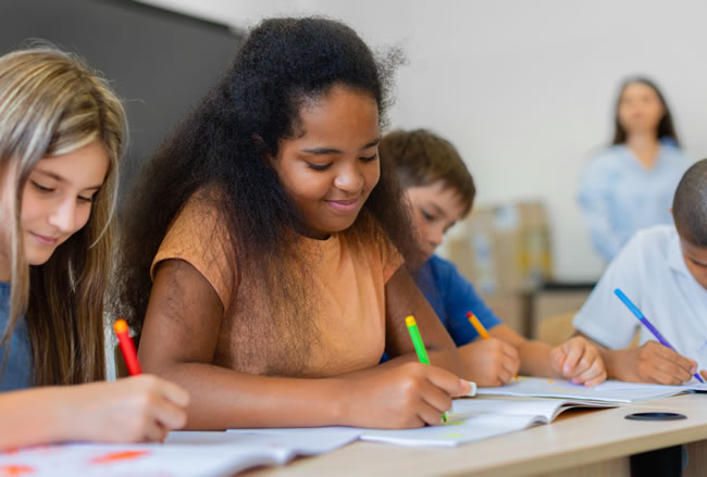 Children writing in classroom