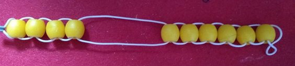 Picture 10 description: A golf stroke counter (bead string) with 10 yellow beads.