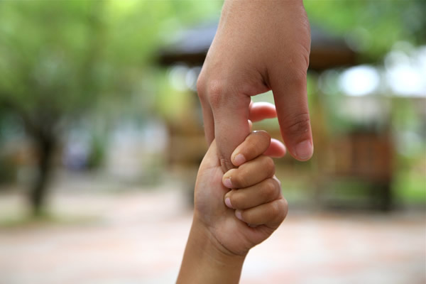 adult hand holding child's hand