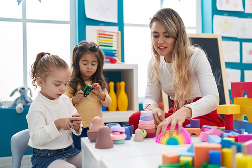 female teacher playing with small children