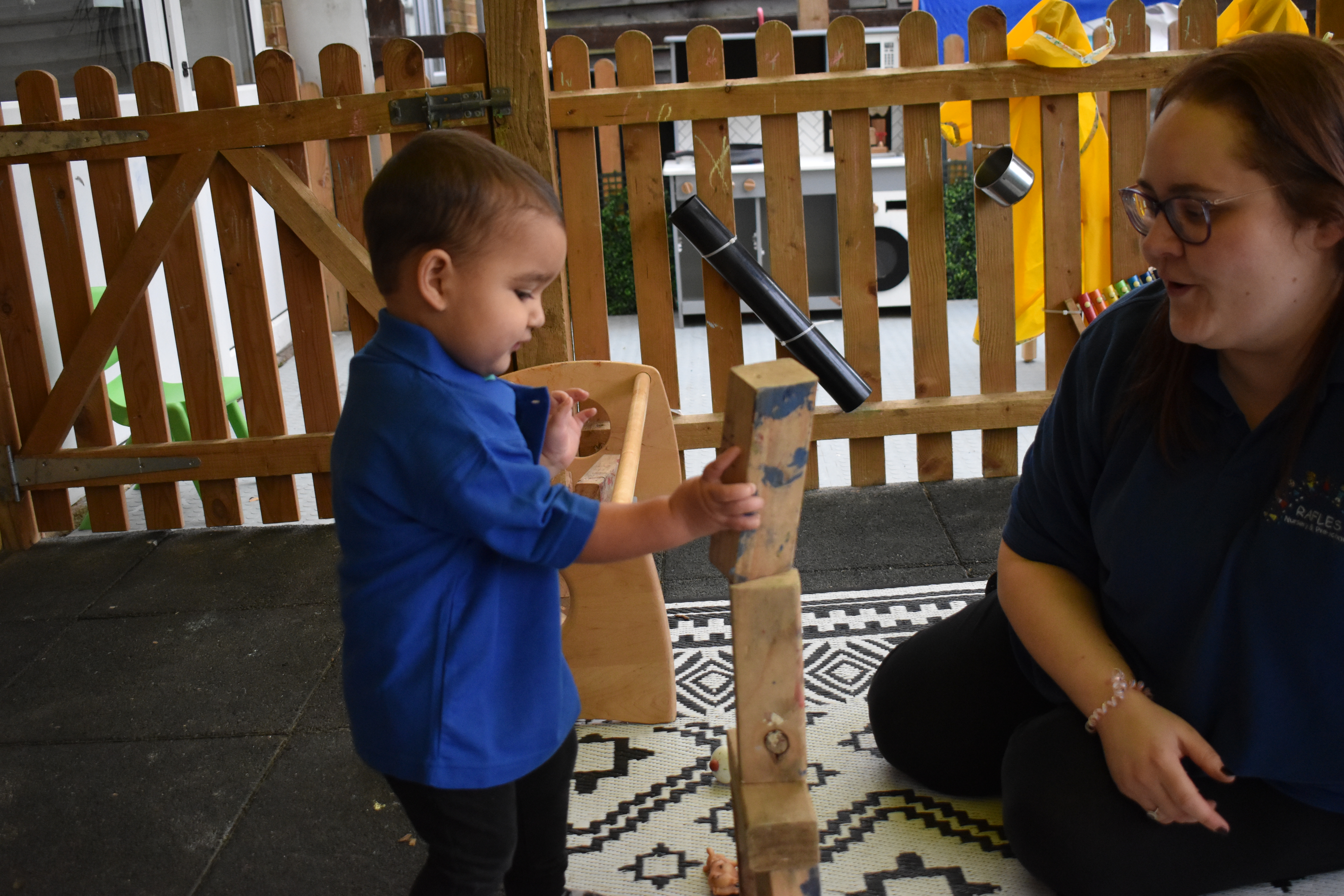 Teacher with Early Years child and bulidng blocks
