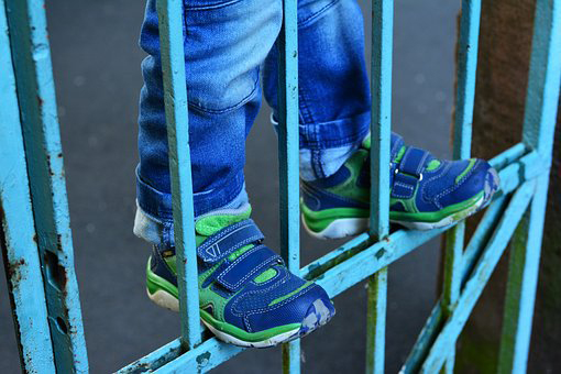 Child standing on fence