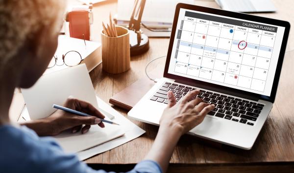 Woman looking at calendar on laptop screen