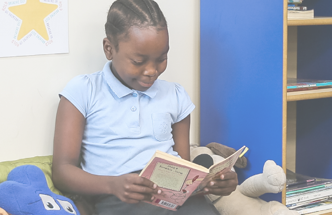 Girl in uniform reading a book