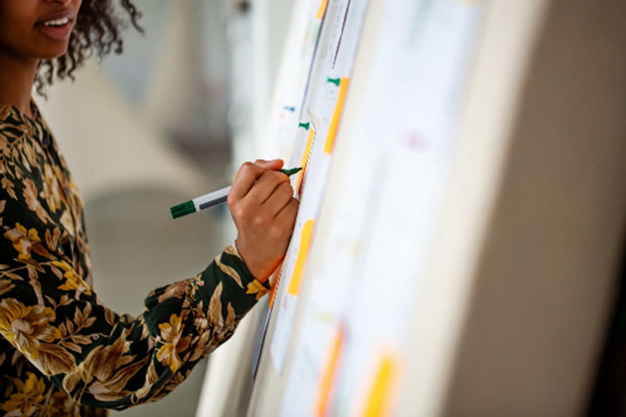 Woman writing on a board with a marker pen