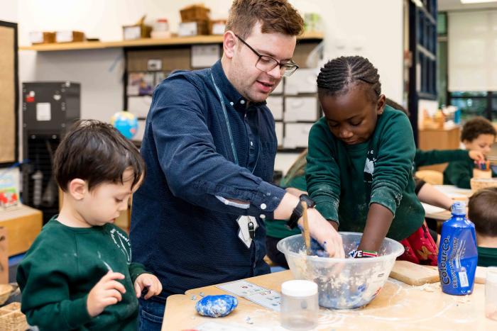 Adult with Early Years children, playing with a bowl