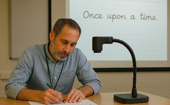 Man practicing handwriting under an over head projector