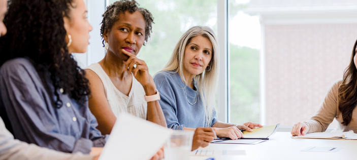 Adults sat at desk with paper work