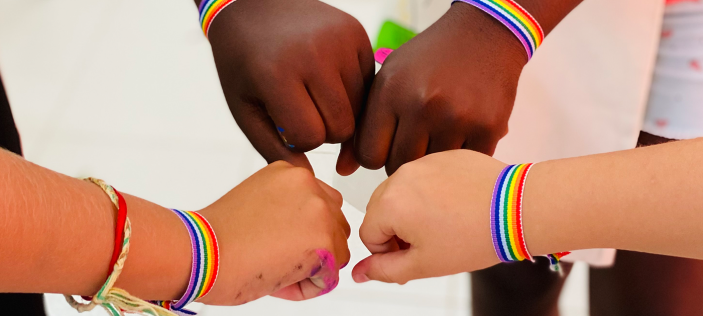 Fist bumps with rainbow wrist straps