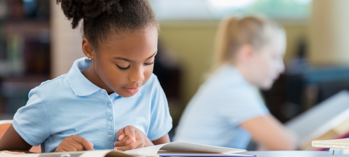 School girl reading from book
