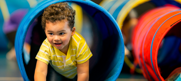 child crawling through a blue tunnel