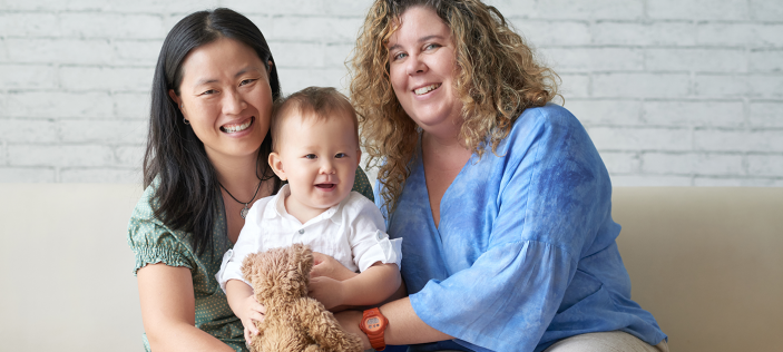 Two women holding a baby