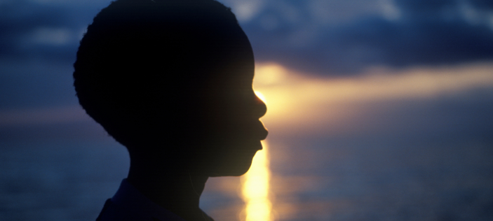 Silhouette of a face against a water sunset