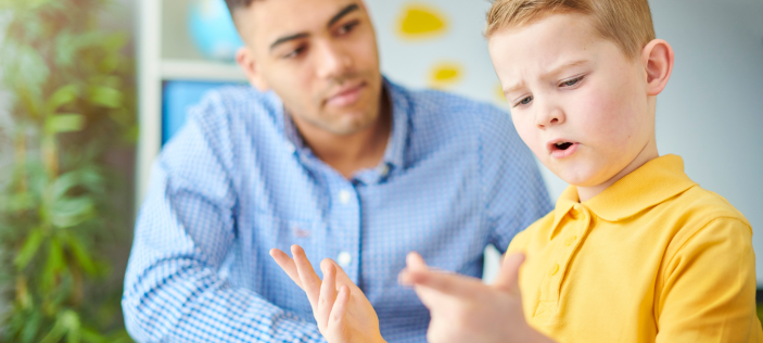 Adult with child in yellow shirt counting on both hands