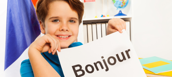 Person holding a sign which says "Bonjour"