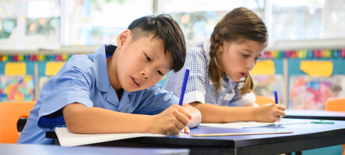 Students writing at desk