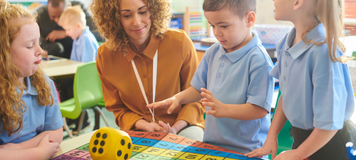 children with teacher and dice
