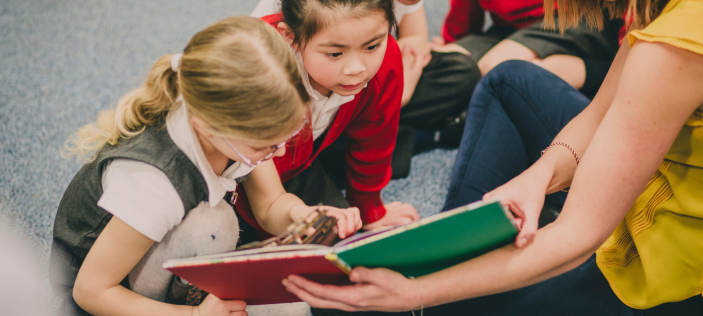 Children looking at book together