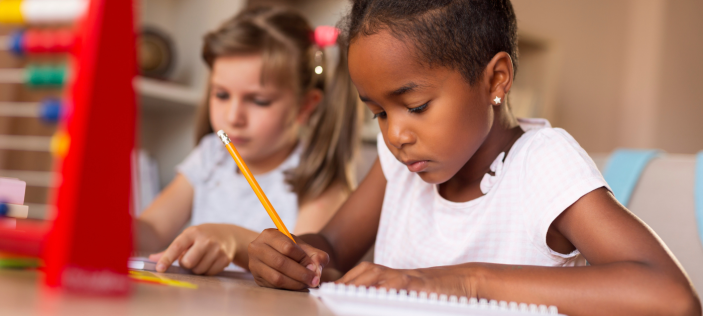 Girl writing in book with pencil