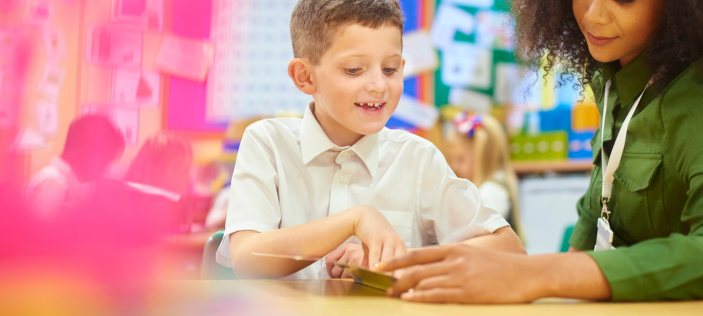 Adult in green shirt with younger school child