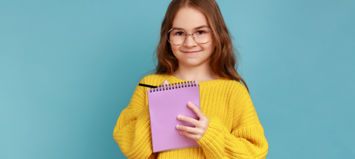 Child writing on a notepad