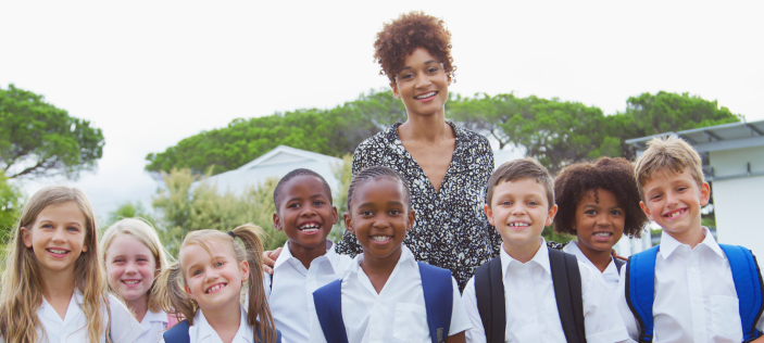 Teacher and pupils smiling for camera