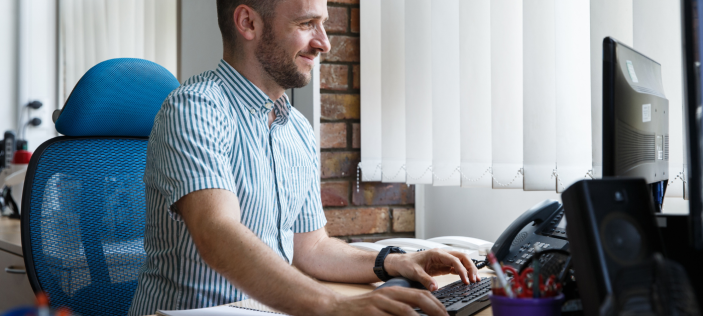 Man typing happily on keyboard