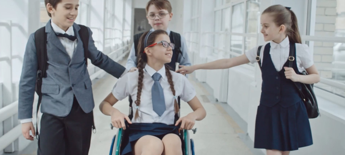 Children with a girl of similar age in a wheelchair