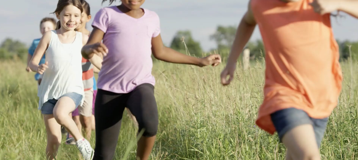 Happy children running through a field