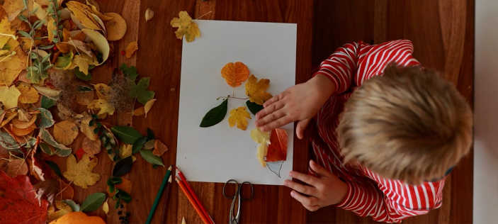 child playing with leaves