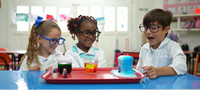Three children sat infront of coloured glasses
