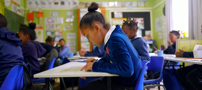 Girl in blue school uniform in a classroom