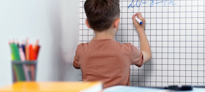 Boy writing on whiteboard