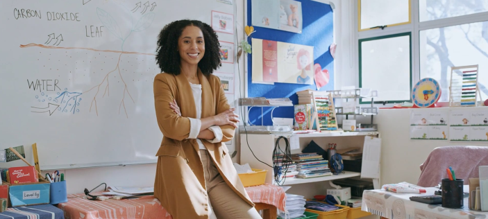Woman sat on desk with her arms folded