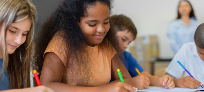 Children writing in classroom