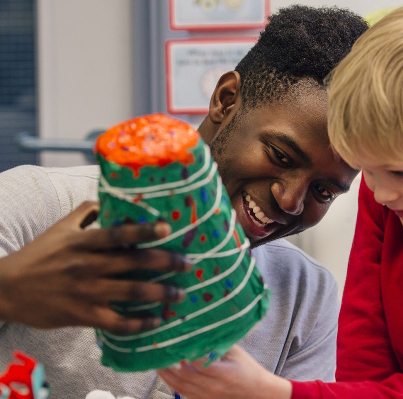 male teacher of colour with 2 primary pupils