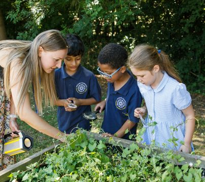 teacher with 2 children in a garden