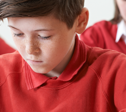 boys in red jumpers writing