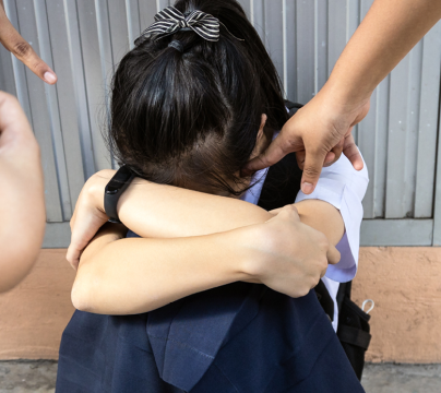 Hands and phones pointing at unhappy child with face hidden