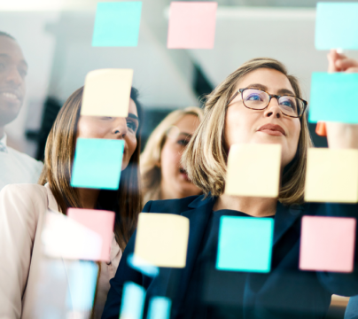 people looking at post it notes on a screen