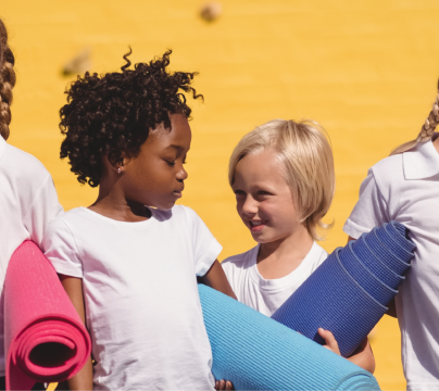 Happy looking school children in front of yellow background