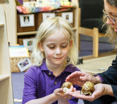 teacher with girl in purple top holding something