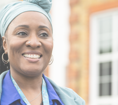 Lady smiling and wearing blue, infront of building