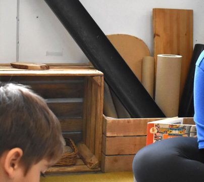 Children sitting on floor listening to practitioner