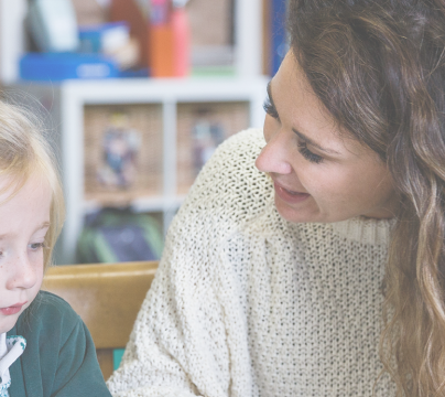 Child and teacher sitting at desk