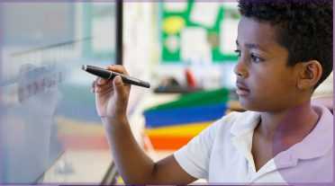 boy of colour writing on a whiteboard