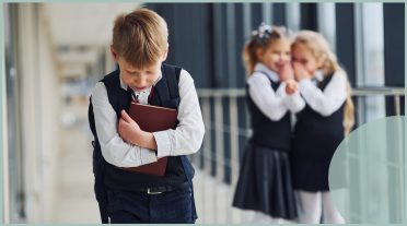 boy looking sad being laughed at by girls